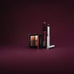Продукти Clinique Black Honey: палетка тіней, туш і Almost Lipstick на темно-сливовому фоні