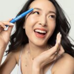 Жінка тримає гель для брів Vaseline Brow Tamer Jelly біля брови