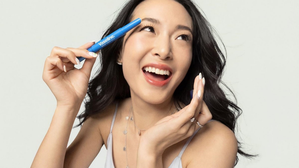 Жінка тримає гель для брів Vaseline Brow Tamer Jelly біля брови