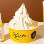 Frozen yogurt Better Summer Swirl у брендованому стакані Kiehl’s x Go Greek поруч із двома сонцезахисними засобами Better Screen