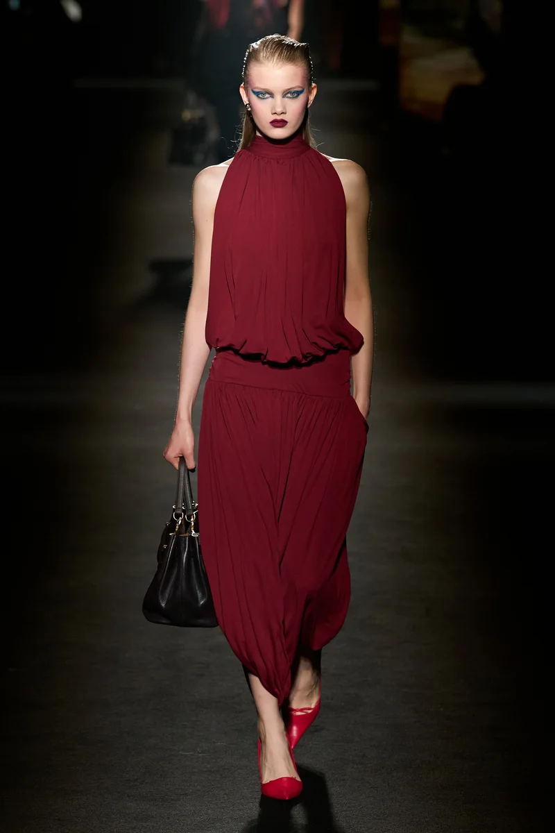 Бордова сукня Balenciaga з відкритими плечима і червоними туфлями