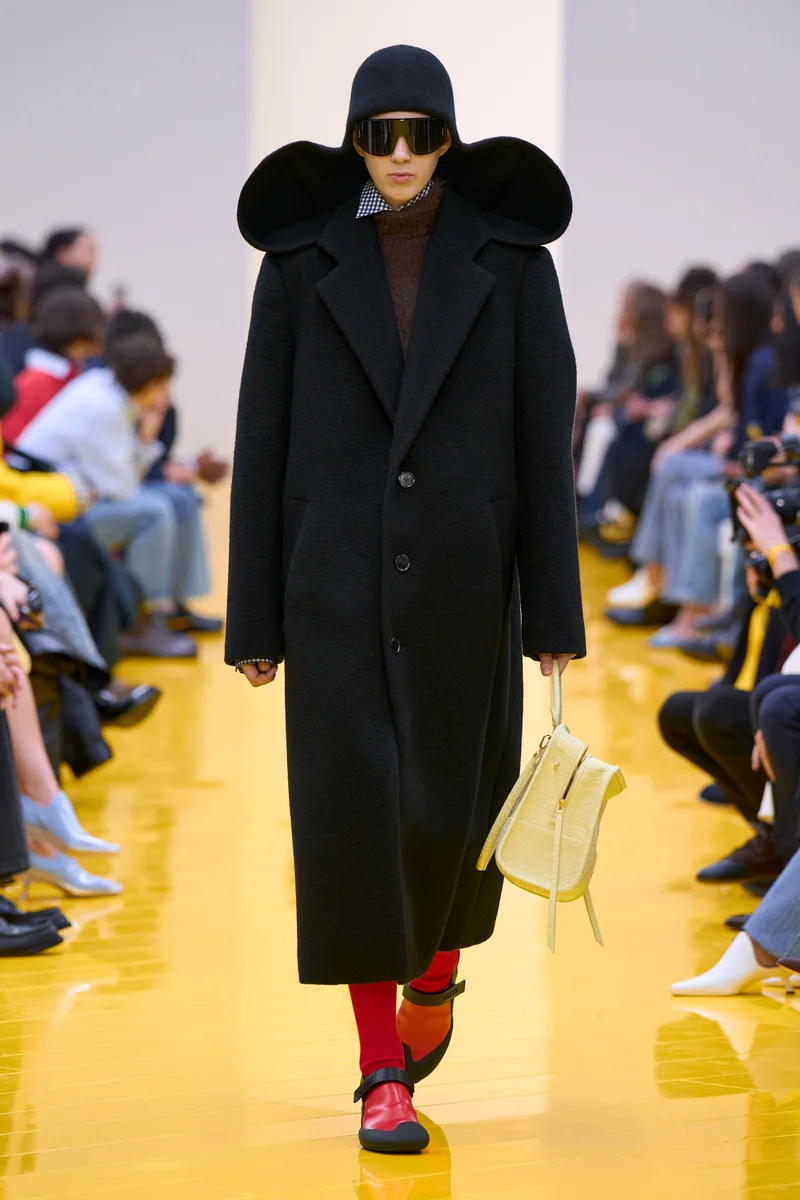 Чорне довге пальто Loewe, капелюх з широкими полями, червоні шкарпетки і червоні туфлі, осінь-зима 2026-2027