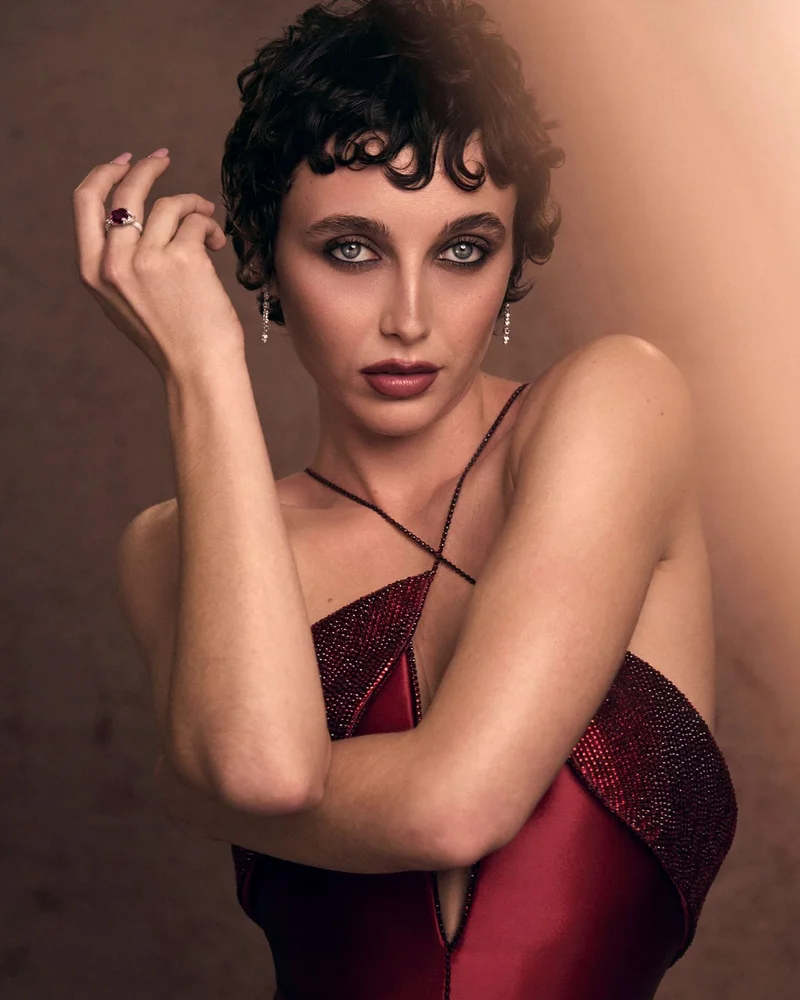 Емма Чемберлен у червоній сукні Armani, рука біля обличчя, сережки з темними каменями