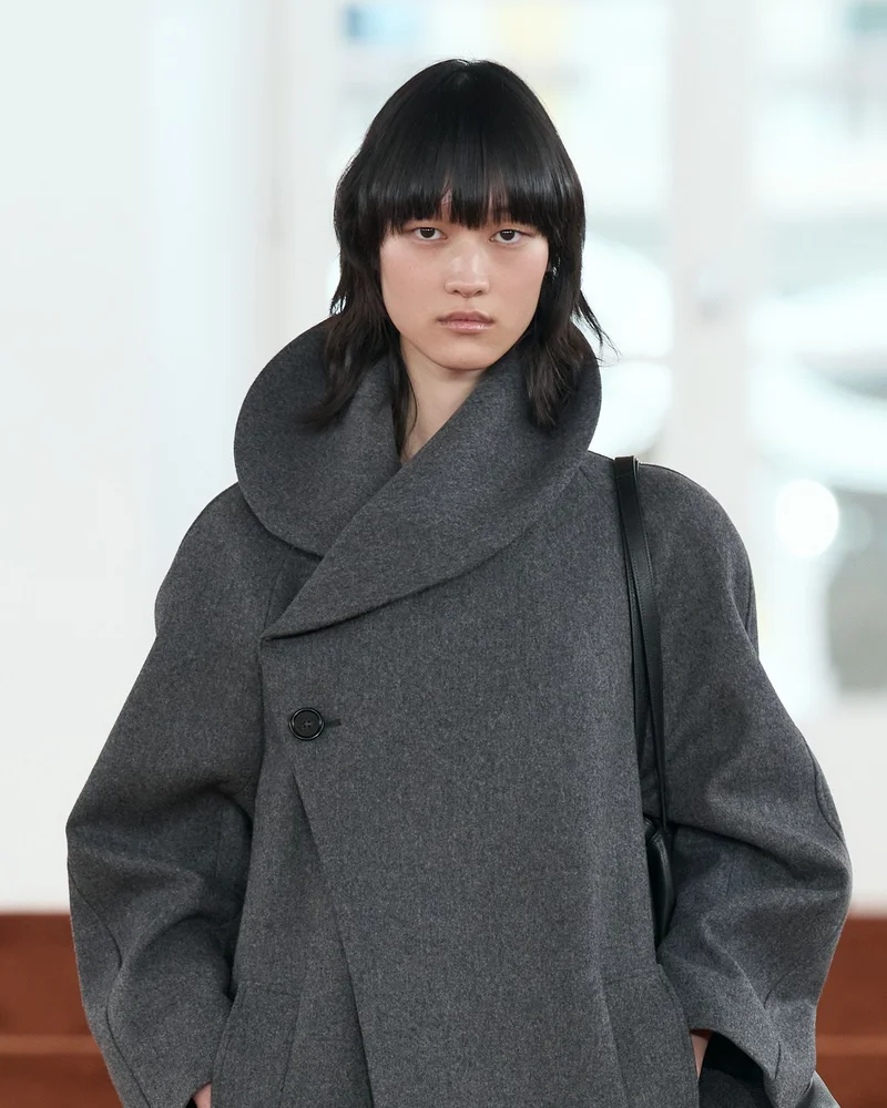 Модель з темним каре з рваними кінчиками і чубчиком у сірому пальті Jil Sander осінь-зима 2026-2027