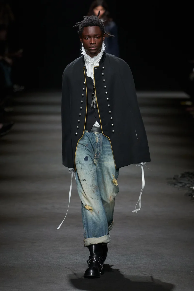 Чорна накидка-жакет Ann Demeulemeester з рядами ґудзиків, сорочка з жабо і рвані джинси