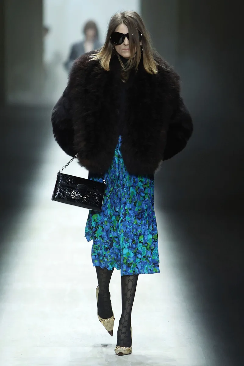 Короткий чорний пухнастий жакет, синя спідниця з принтом і чорна сумка Gucci, осінь-зима 2026-2027