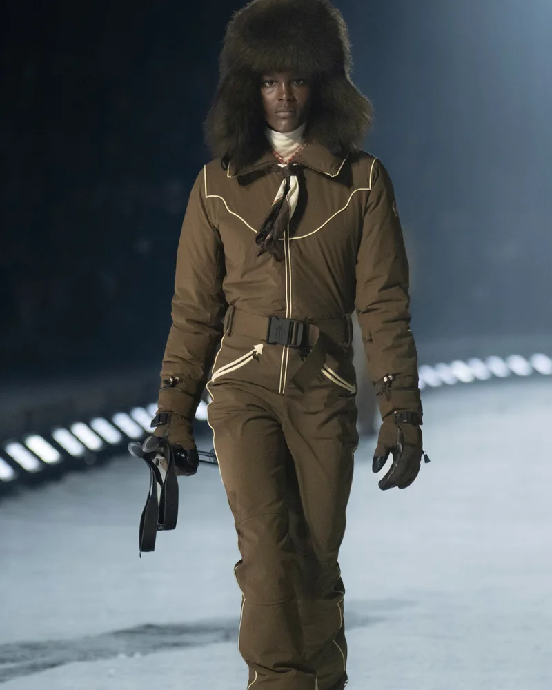 Модель Moncler Grenoble у великій темній хутряній вушанці і костюмі кольору хакі з поясом