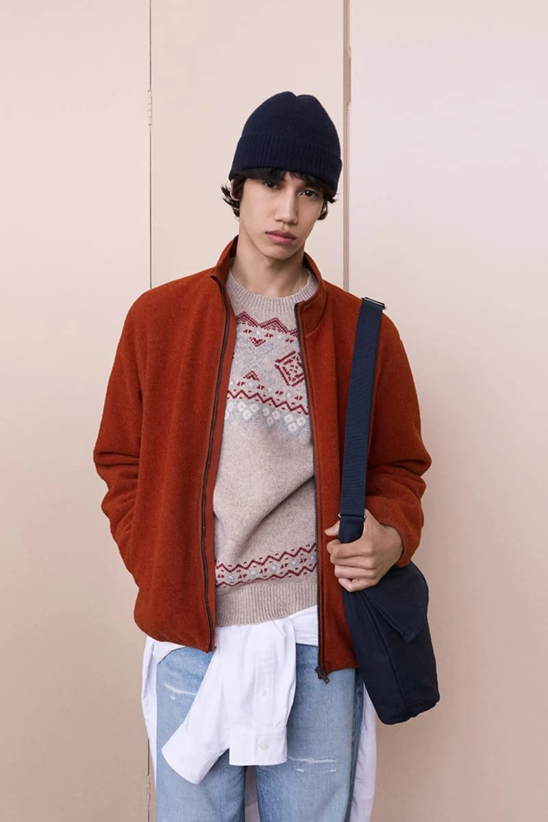 Теракотовий флісовий блузон поверх светра з орнаментом і світлі джинси, Uniqlo і JW Anderson