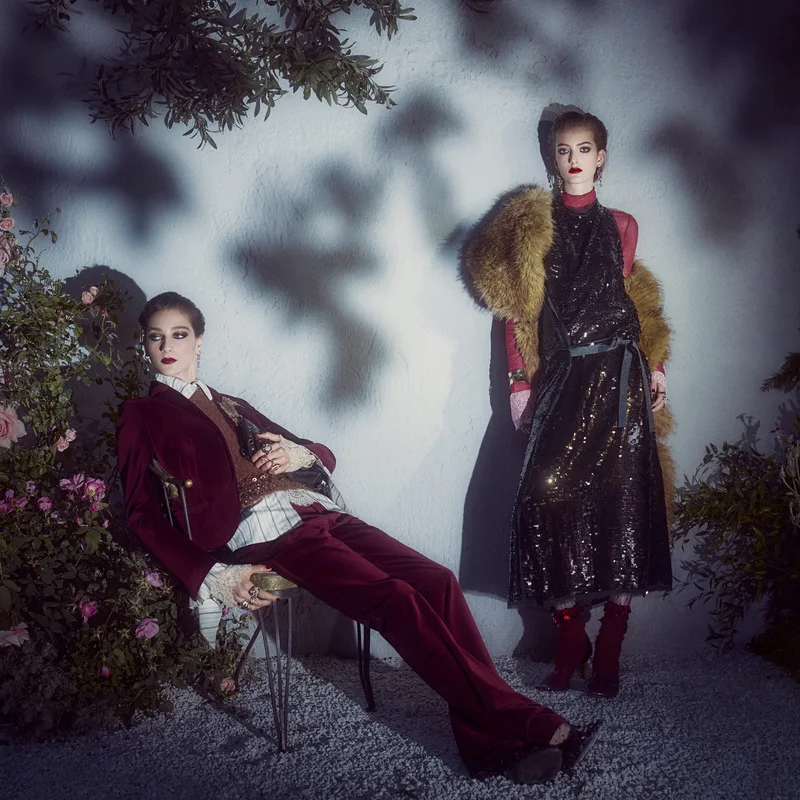 Дві моделі в кампанії Zara Studio осінь-зима 2026: бордовий оксамитовий костюм з мереживною сорочкою і чорна сукня з паєток з хутряним палантином